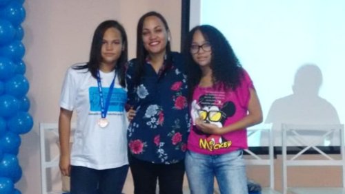 Aisha na premiação da OBMEP, após conquista do bronze, com a irmã e a mãe Roseli.